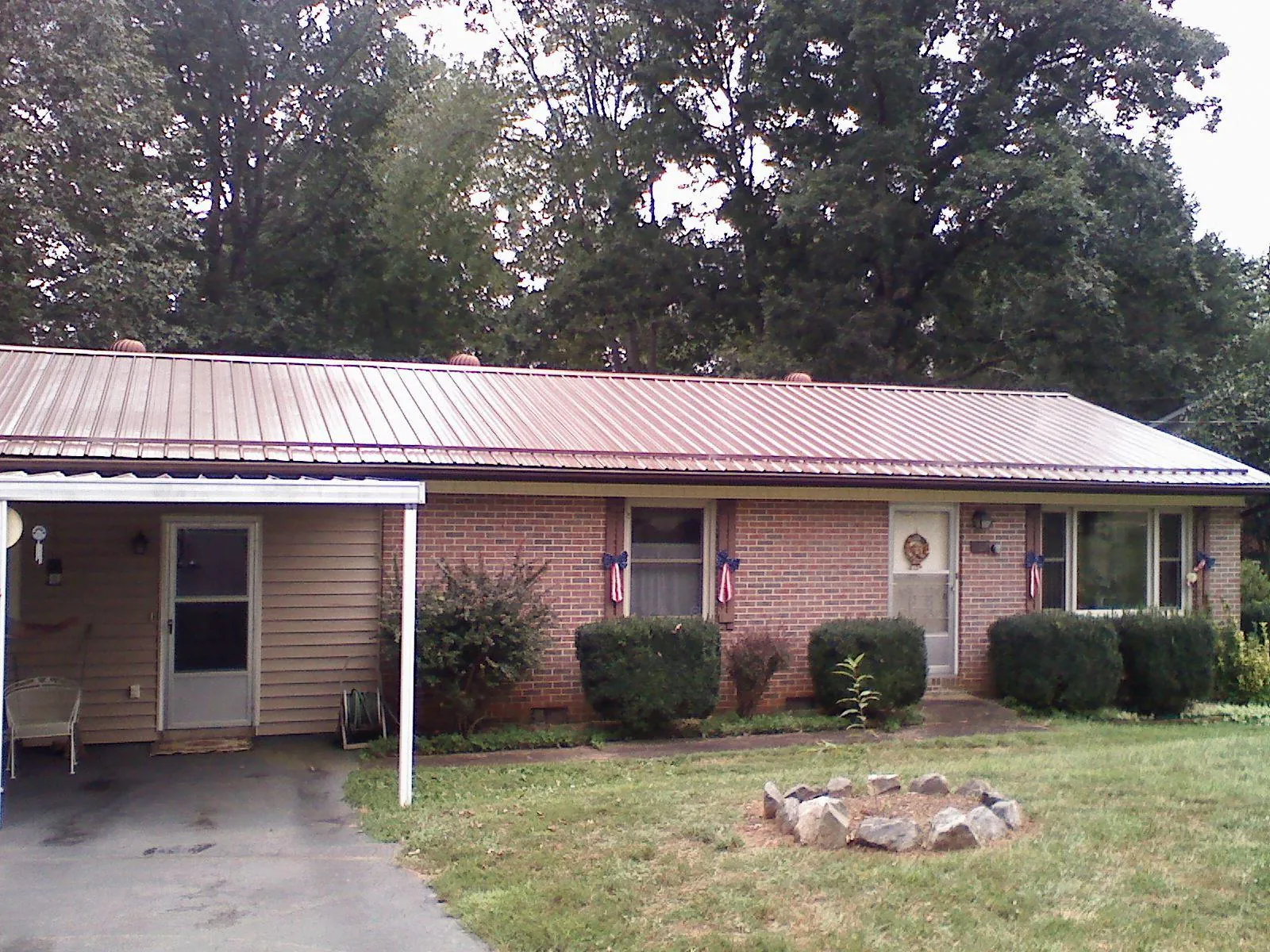 Bronze metal roof and carport on a brick ranch home — Roof Repair work by our crew in Bonner