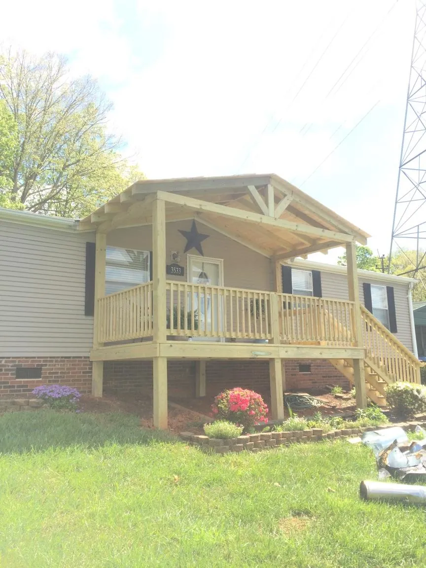 New gabled porch roof and deck railing added to a ranch home in Bonner